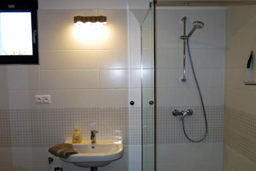 ein Bad mit einer Dusche und einem Waschbecken in der Unterkunft Scandic apartmany in Veľký Meder