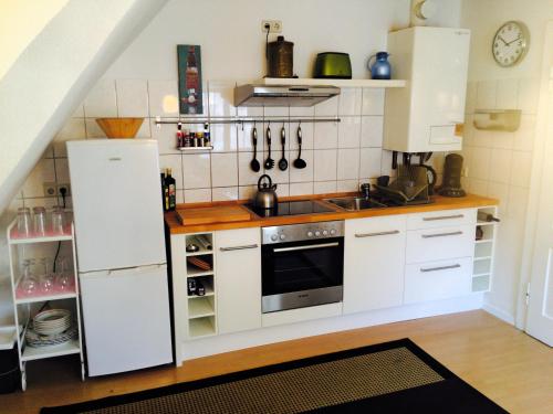 バーデン・バーデンにあるBaden Apartmentの白いキャビネット、シンク、冷蔵庫付きのキッチンが備わります。