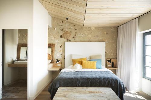 a bedroom with a bed with yellow and blue pillows at Le 19-21 - Un amour d'hotel in Leucate