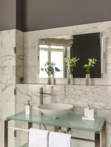 a bathroom with a sink and a mirror at Roosevelt Stadthaus in Vienna