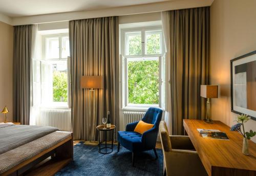 a hotel room with a bed and a desk and a chair at Roosevelt Stadthaus in Vienna