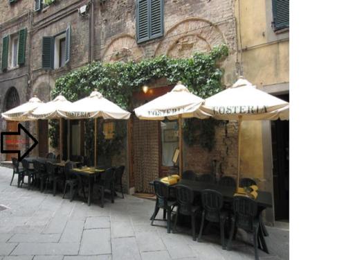 an outdoor cafe with tables and chairs and umbrellas at B&B Dei Rossi in Siena