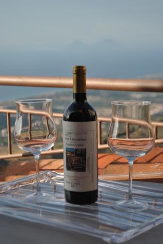 a bottle of wine and two wine glasses on a table at Bed & Breakfast StudioArcodia- in San Marco dʼAlunzio