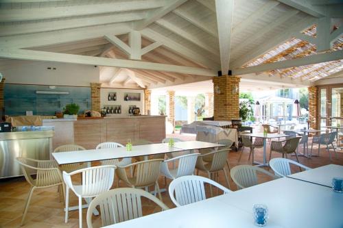 a restaurant with tables and chairs and a kitchen at Eliantos Boutique Hotel & Spa in Santa Margherita di Pula