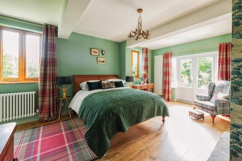 a bedroom with green walls and a bed and a chair at The Coach House in Derby