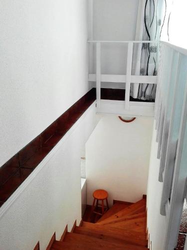 a stairway with a stool and a stair case at Alojamento Bela Vista in Lajes do Pico