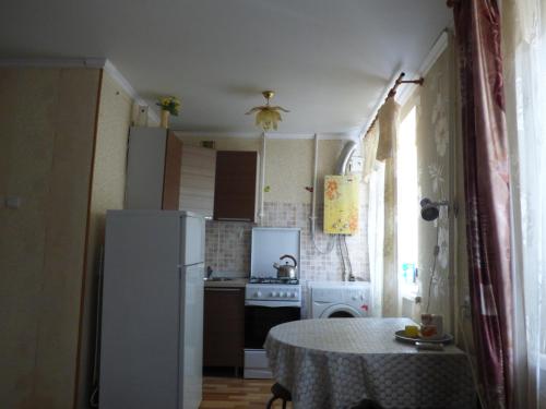 アストラハンにあるApartment on Zdorovtsevaのキッチン(テーブル、白い冷蔵庫付)