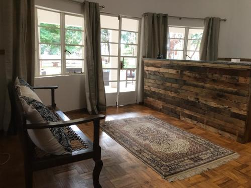 a living room with a chair and windows at The Doors Inn in Mokopane