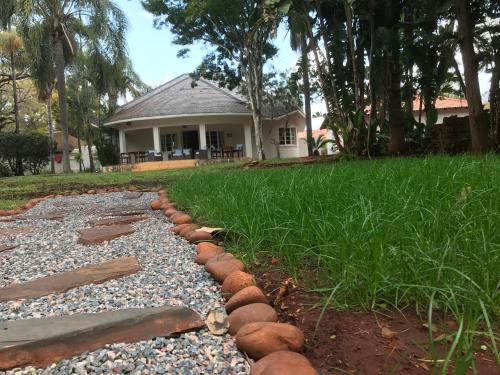 a garden with rocks and grass and a house at The Doors Inn in Mokopane