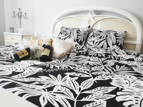 a bed with a black and white comforter and pillows at Apartments & Pool Villa White House in Pančevo