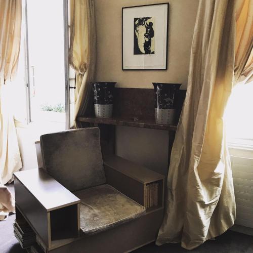 a chair and a table in a room with a window at Hôtel Particulier Le 28 - Spa & Art Luxury Design by Alain Ducasse in Aix-en-Provence