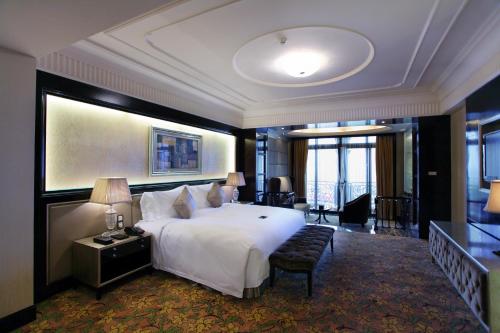 a large hotel room with a large bed and a couch at Chateau Star River Pudong Shanghai in Shanghai