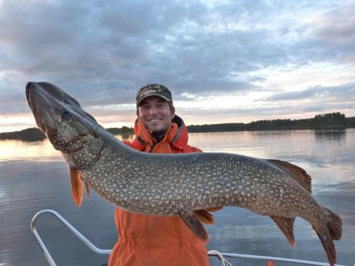 a man holding a large fish on a boat at Oravi Villas in Oravi