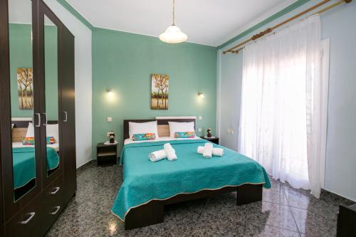 a bedroom with a bed with blue walls and a window at Casa Del Sol in Skala Marion