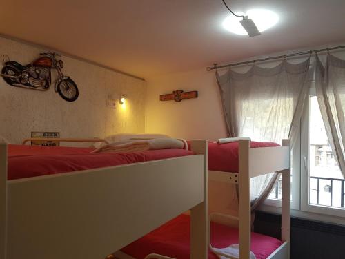 a bedroom with two bunk beds and a window at Barri Antic Hostel & Pub in Andorra la Vella