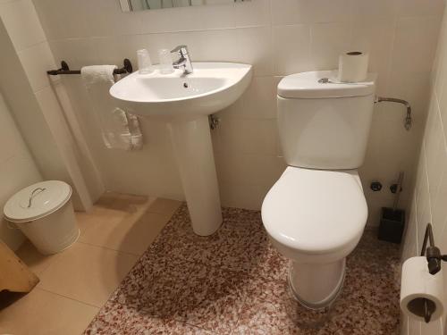 a bathroom with a white toilet and a sink at Barri Antic Hostel & Pub in Andorra la Vella
