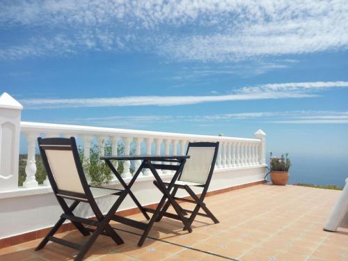a table and two chairs on a balcony with the ocean at Cerro del Pozo in Adra