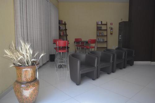 a waiting room with chairs and a vase with plants at Hotel Calstar in Sao Paulo