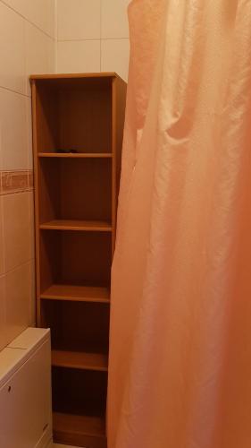 a bathroom with a book shelf next to a toilet at Lara in Solochin