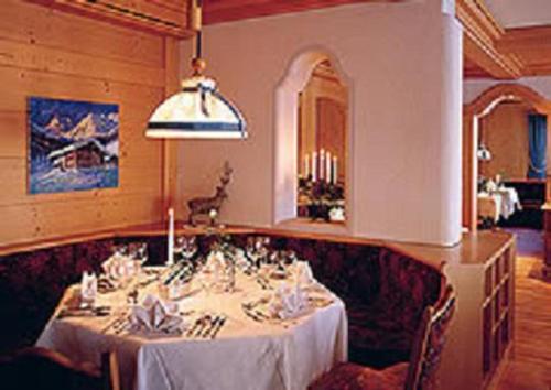 a dining room with a table with a white table cloth at Hotel Omesberg in Lech am Arlberg