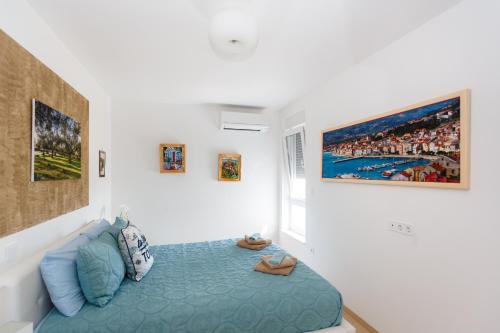 a bedroom with a blue bed in a white room at Apartment Marinela in Krk