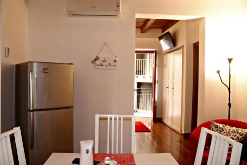 eine Küche mit einem Kühlschrank und einem Tisch mit Stühlen in der Unterkunft La Casetta di Clara in Palermo