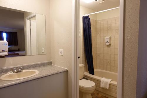 a bathroom with a sink and a toilet and a mirror at Armada Inn Motel in Unity