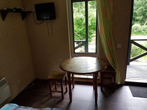 a room with a table and a tv and a window at Pinedune Beach in Saulkrasti