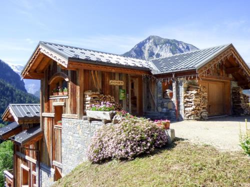 a house with a mountain in the background at Chalet des Trappeurs Coeur Vanoise 15 persons in Champagny-en-Vanoise