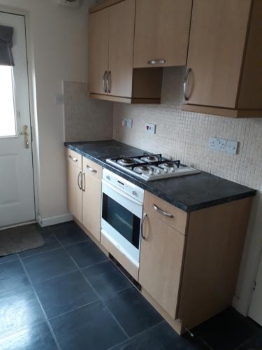 a kitchen with a stove and a counter top at Handy Dale House in Bathgate