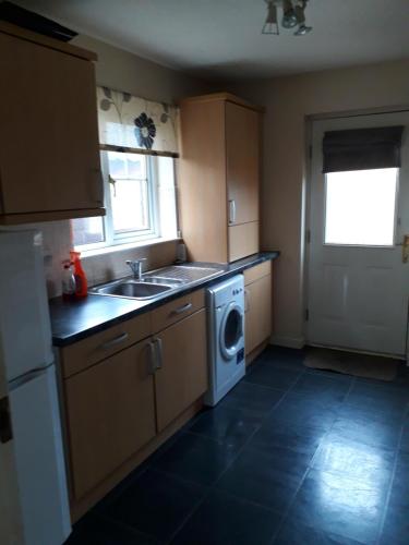 a kitchen with a sink and a washing machine at Handy Dale House in Bathgate