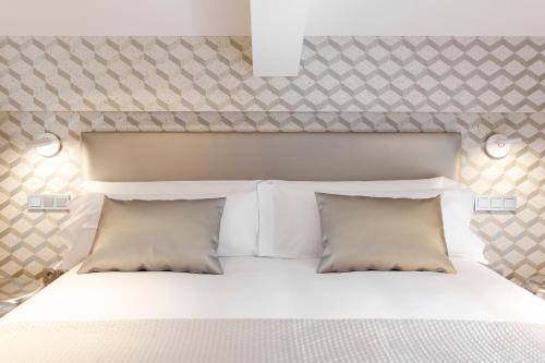 a bedroom with a white bed with two pillows at Villa Birdie Boutique - Adults Only in Donostia-San Sebastián