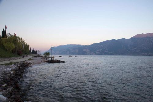 a large body of water with mountains in the background at Hotel Vela Azzurra in Malcesine