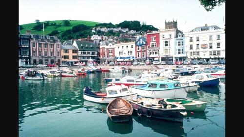 eine Gruppe von Booten liegt in einem Hafen vor Anker in der Unterkunft Nancie's Place - DARTMOUTH TOWN CENTER with PRIVATE PARKING - A Traditional Georgian PRIVATE DUPLEX APARTMENT - BEAUTIFULLY REFURBISHED - TWO BEDROOMS, BATHROOM, KITCHEN and LOUNGE DINER in Dartmouth