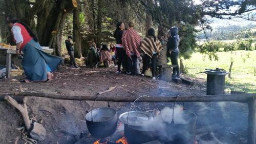 a group of people standing around a camp fire at Hacienda EL SINCHE in Machachi