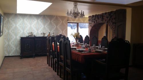 a dining room with a table and chairs and a chandelier at Hacienda EL SINCHE in Machachi