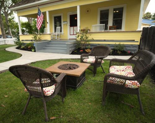 un grupo de sillas y una mesa frente a una casa en Poppy Sister Inn en Lodi