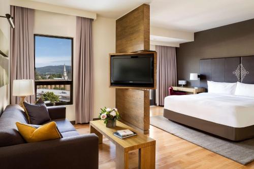 ナパにあるアンダーズ ナパ ア コンセプト バイ ハイアットのベッド1台、薄型テレビが備わるホテルルームです。