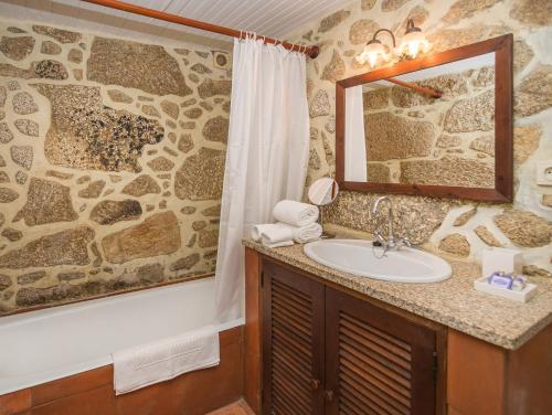 y baño con lavabo y espejo. en Casas de Massinos, en Barroselas
