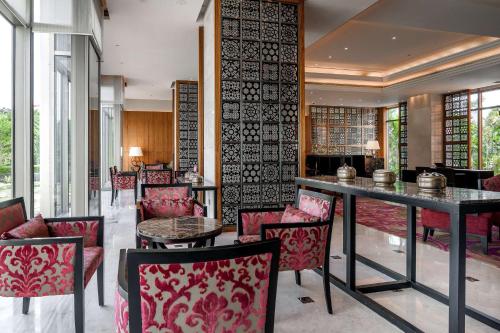 a restaurant with red chairs and a table in a room at Hyatt Ahmedabad in Ahmedabad