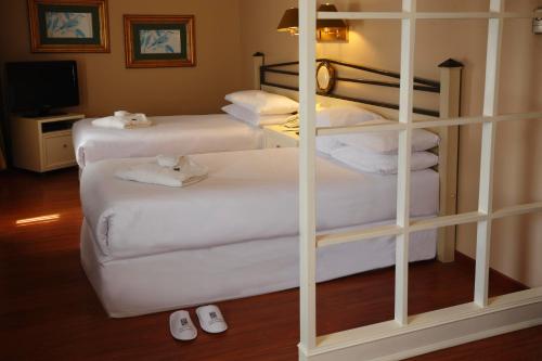 a room with three bunk beds with white sheets at Suites del Bosque Hotel in Lima