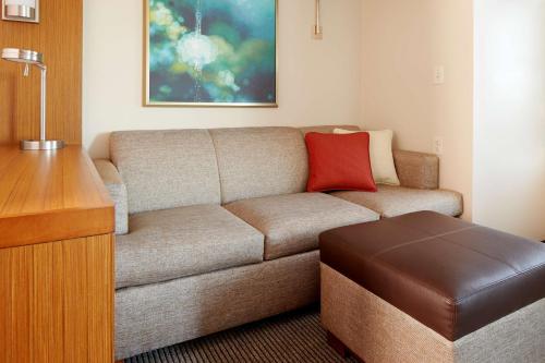 a living room with a couch and a red pillow at Hyatt Place Columbus in Columbus