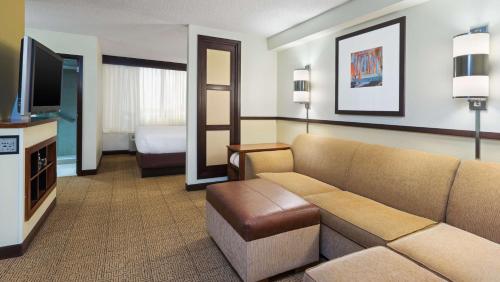 a hotel room with a couch and a television at Hyatt Place Fort Lauderdale Cruise Port & Convention Center in Fort Lauderdale