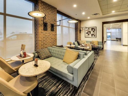 a lobby with a couch and chairs and tables at Hyatt Place Edmonton West in Edmonton