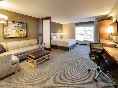 a hotel room with a bed and a couch at Hyatt Place Edmonton West in Edmonton