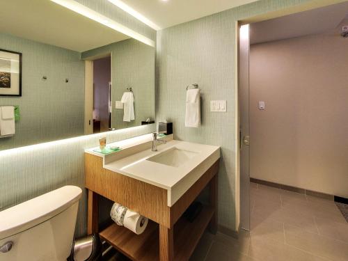 a bathroom with a sink and a toilet and a mirror at Hyatt Place Edmonton West in Edmonton