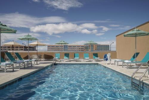 奧羅拉的住宿－Hyatt Regency Aurora-Denver Conference Center，屋顶游泳池,配有椅子和遮阳伞