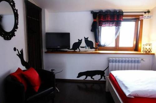 a bedroom with three cats sitting on a window sill at Zajazd U Dudziarza in Kościan