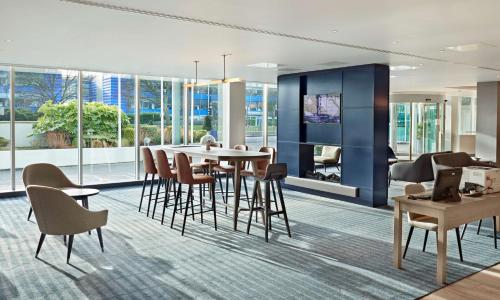 a dining room with a table and chairs at Hyatt Place London Heathrow Airport in Hillingdon