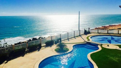 an aerial view of a swimming pool next to the ocean at EmanuelleSales - Corretora de Imóveis - "LUXURY RESIDENCES" creci 16949F in Canoa Quebrada